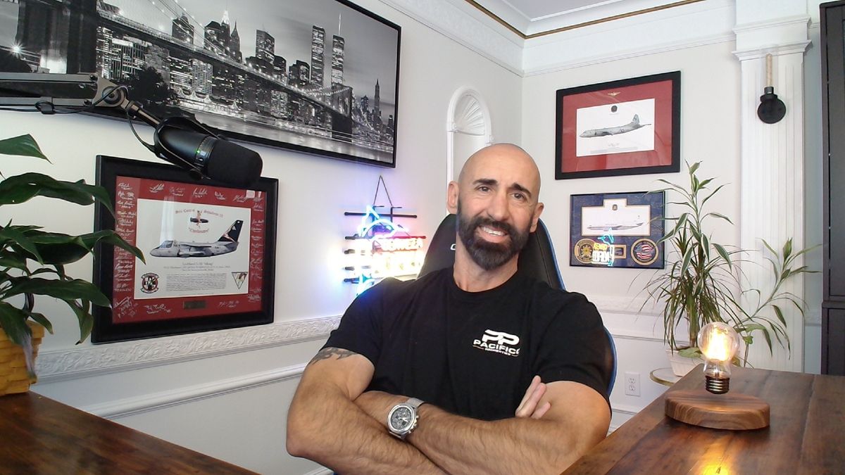 Peter Pacifico, broker-owner, in his office with framed military aircraft prints